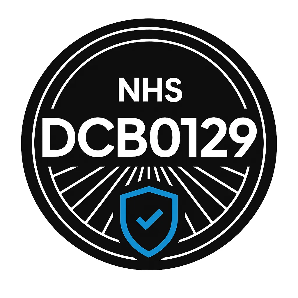 Round black NHS badge with white text DCB0129 and a blue shield with check mark below.